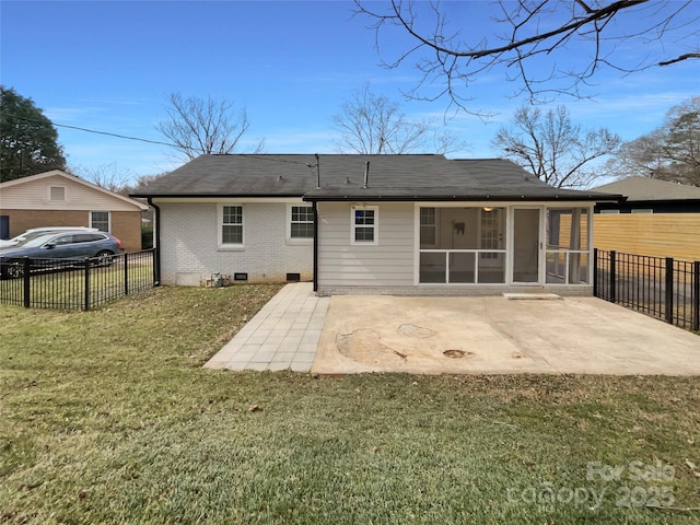 rear view of property featuring a patio, a sunroom, fence, a yard, and brick siding