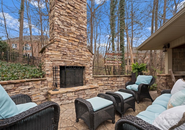 view of patio featuring an outdoor living space with a fireplace and fence