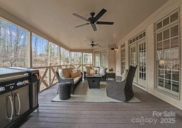 sunroom / solarium featuring a ceiling fan