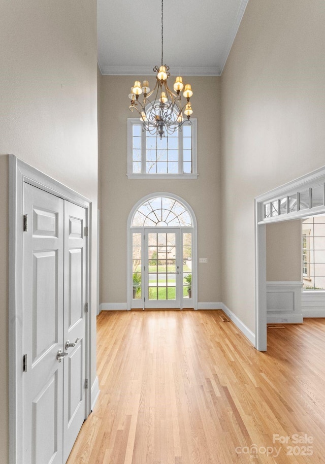 interior space featuring a healthy amount of sunlight, a chandelier, and ornamental molding