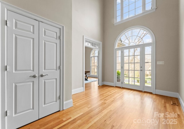 foyer entrance featuring plenty of natural light, baseboards, and wood finished floors