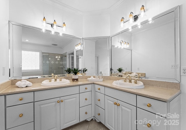 full bath featuring double vanity, a shower stall, crown molding, and a sink