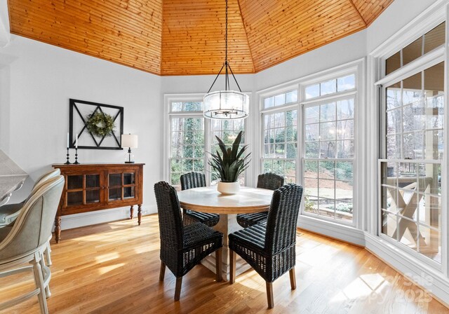 dining space featuring a notable chandelier, high vaulted ceiling, and light wood finished floors