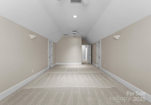 empty room featuring baseboards, light carpet, lofted ceiling, and a ceiling fan