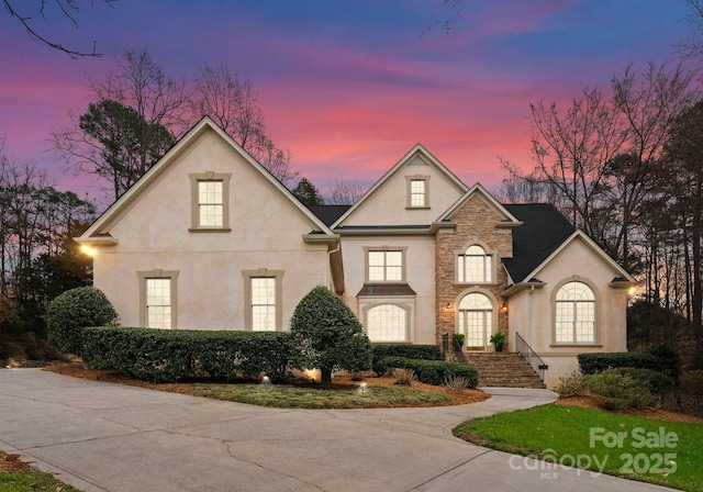 french country inspired facade with stucco siding and stone siding