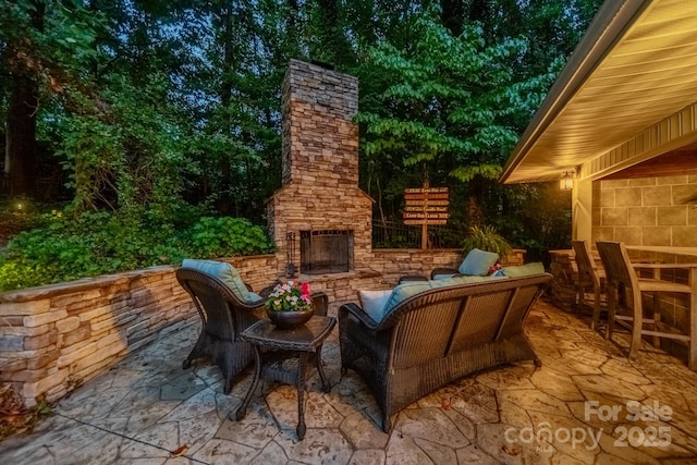 view of patio with an outdoor living space with a fireplace