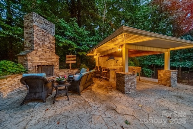 view of patio featuring a gazebo, outdoor dry bar, and an outdoor living space with a fireplace