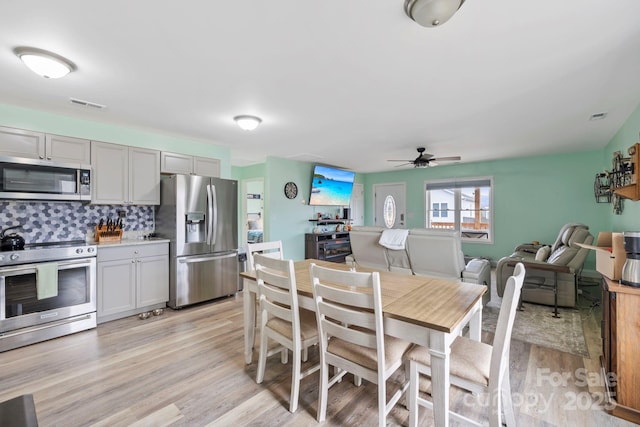 dining room featuring visible vents, a ceiling fan, and light wood-style floors