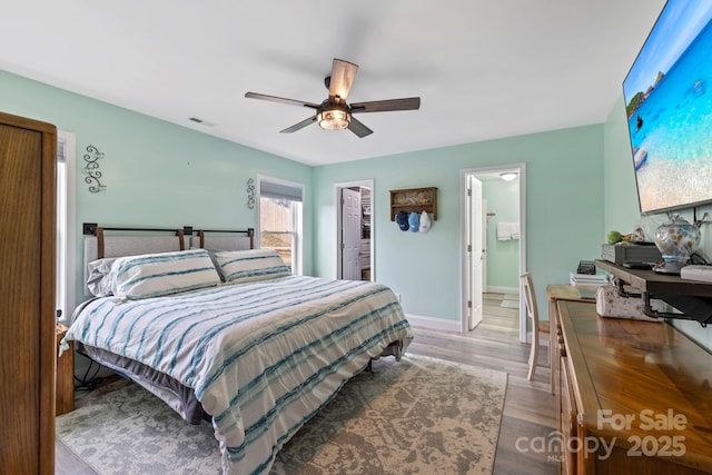 bedroom featuring visible vents, a ceiling fan, wood finished floors, baseboards, and a spacious closet