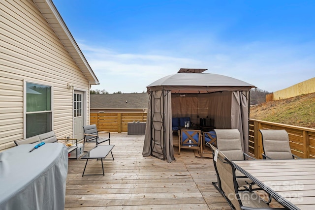 deck featuring a gazebo, an outdoor living space, and outdoor dining area