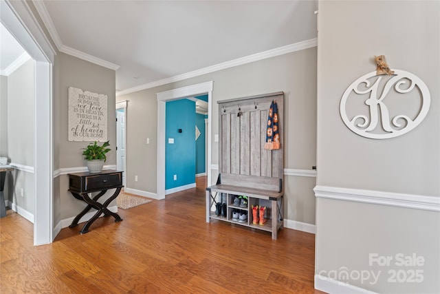 entrance foyer featuring crown molding, baseboards, and wood finished floors