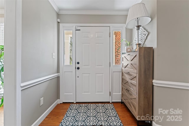 foyer entrance with a wealth of natural light, crown molding, and wood finished floors