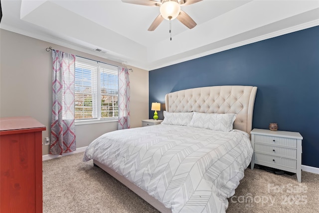 bedroom with a ceiling fan, a raised ceiling, carpet flooring, and baseboards