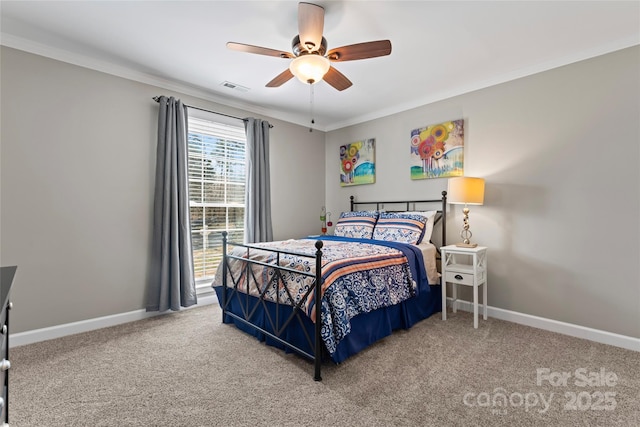 carpeted bedroom with ceiling fan, ornamental molding, visible vents, and baseboards