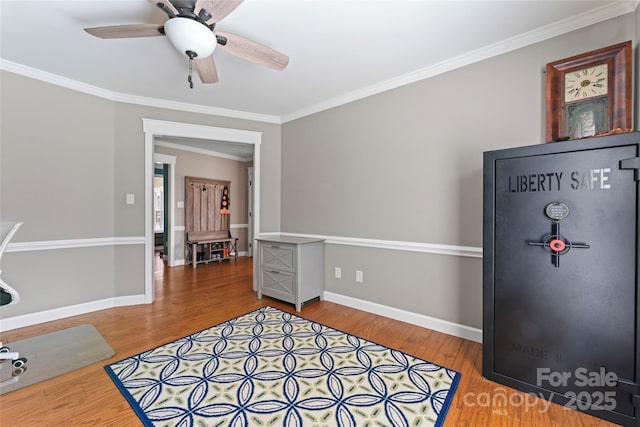 interior space featuring ornamental molding, baseboards, and wood finished floors