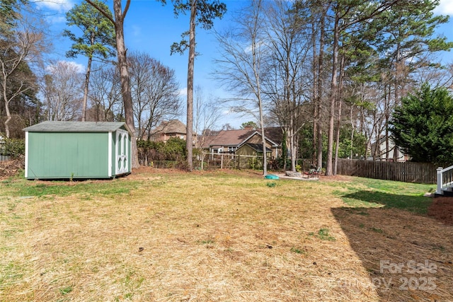 view of yard with a storage unit, an outdoor structure, and fence