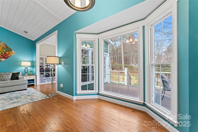 entryway with a healthy amount of sunlight, vaulted ceiling, baseboards, and wood finished floors