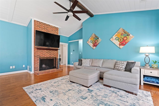 living area with lofted ceiling with beams, crown molding, wood finished floors, and baseboards