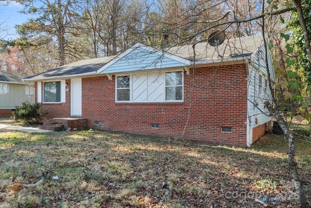 view of front of home with crawl space, a front yard, and brick siding