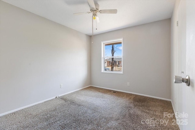 spare room featuring ceiling fan, baseboards, and carpet