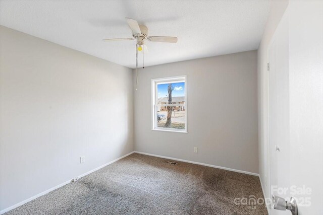 spare room with visible vents, baseboards, carpet, and a ceiling fan