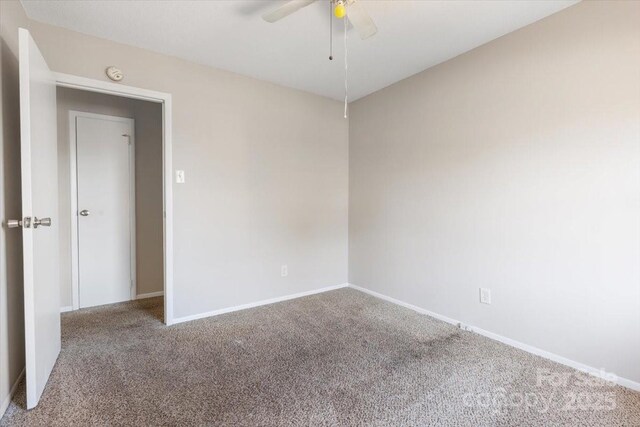 carpeted empty room featuring baseboards and ceiling fan