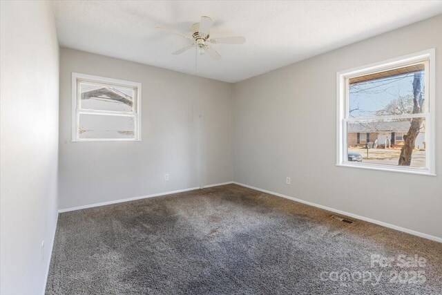 unfurnished room featuring visible vents, baseboards, carpet floors, and a ceiling fan