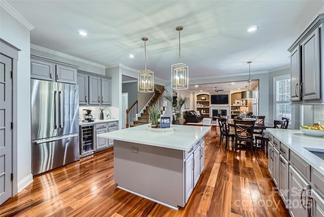 kitchen with a fireplace, wine cooler, high quality fridge, and gray cabinetry