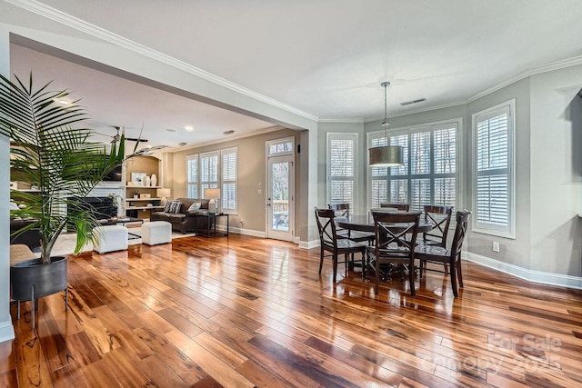 dining room featuring baseboards, ornamental molding, and hardwood / wood-style flooring