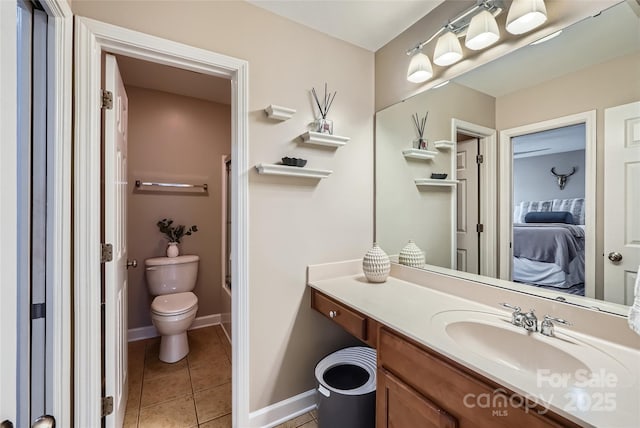 full bath with tile patterned flooring, baseboards, toilet, ensuite bath, and vanity