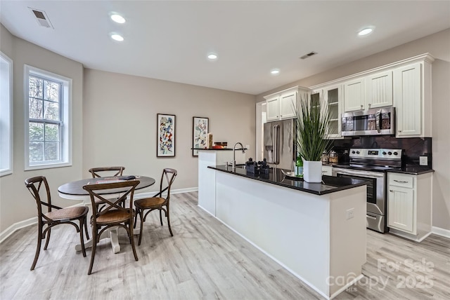 kitchen with visible vents, dark countertops, appliances with stainless steel finishes, and decorative backsplash