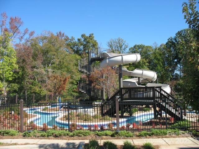 view of basketball court featuring a community pool and fence