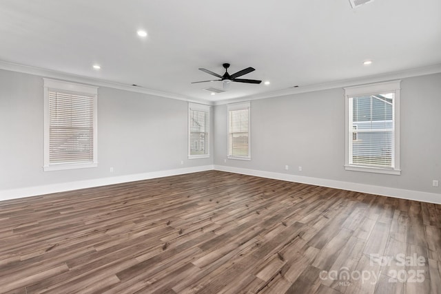 empty room featuring baseboards, crown molding, and wood finished floors