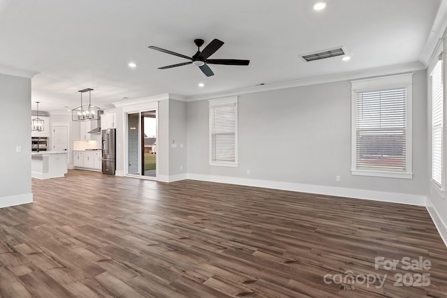 unfurnished living room with ceiling fan with notable chandelier, ornamental molding, dark wood-style flooring, and visible vents