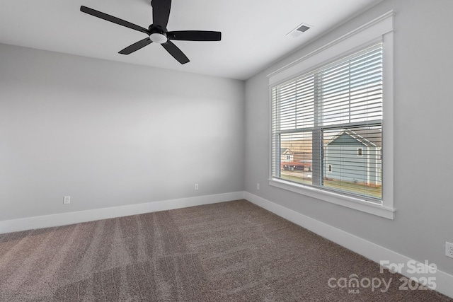 carpeted spare room featuring visible vents, baseboards, and a ceiling fan