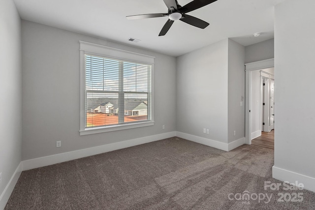 spare room featuring carpet, visible vents, ceiling fan, and baseboards