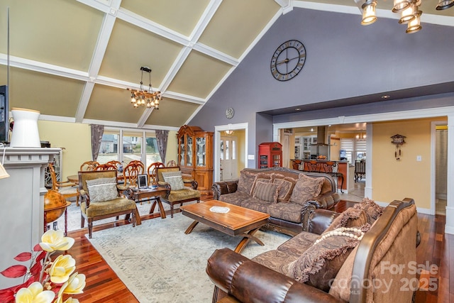 living area featuring a notable chandelier, wood finished floors, and high vaulted ceiling