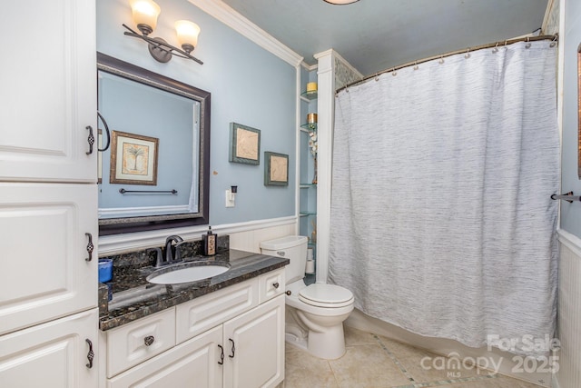 bathroom with tile patterned flooring, a wainscoted wall, toilet, ornamental molding, and vanity