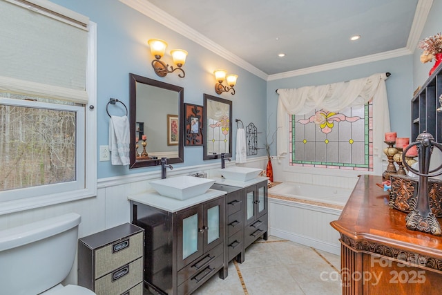 full bath featuring tile patterned flooring, crown molding, a garden tub, wainscoting, and vanity