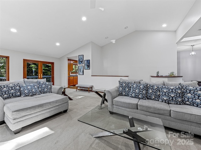 living room with an inviting chandelier, recessed lighting, vaulted ceiling, and light colored carpet