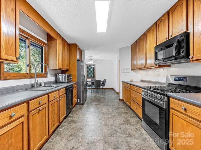 kitchen featuring brown cabinetry, a ceiling fan, a sink, a textured ceiling, and black appliances