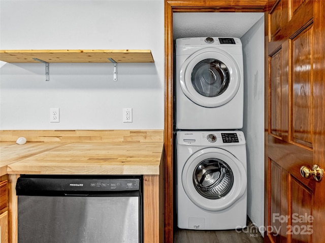 washroom featuring stacked washer and clothes dryer and laundry area