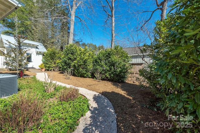 view of yard featuring central AC unit and fence