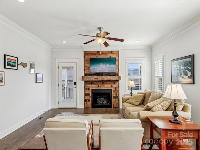 living area with a large fireplace, ornamental molding, dark wood-style floors, and baseboards