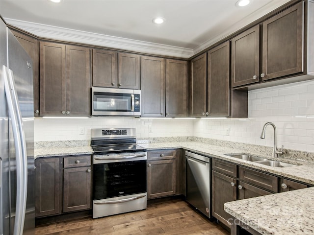 kitchen with dark wood-style floors, dark brown cabinets, stainless steel appliances, and a sink