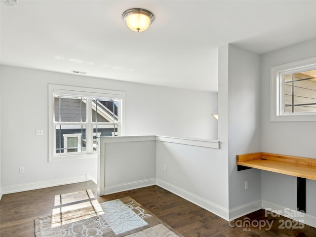 interior space with wood finished floors, visible vents, and baseboards