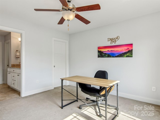 home office featuring light carpet, ceiling fan, and baseboards