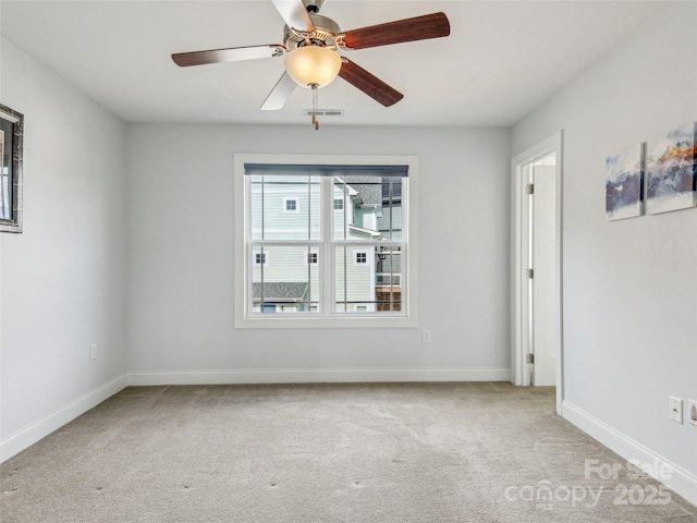 unfurnished room with carpet, visible vents, ceiling fan, and baseboards