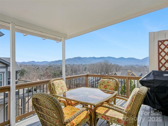 balcony with outdoor dining space, a deck with mountain view, and grilling area