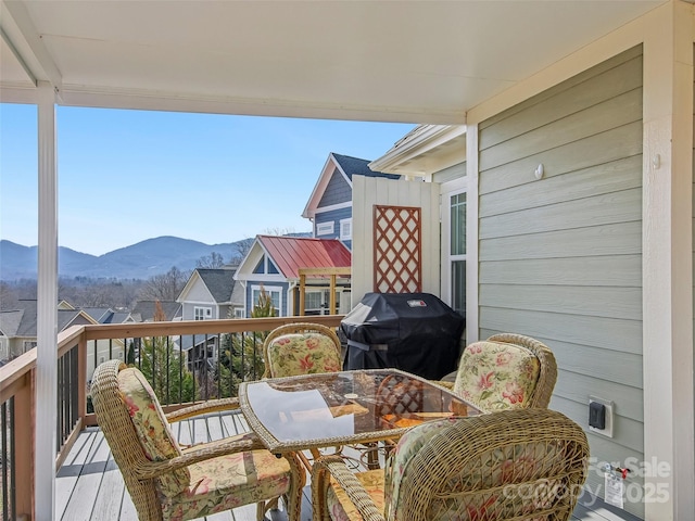 balcony featuring outdoor dining area, a mountain view, and area for grilling